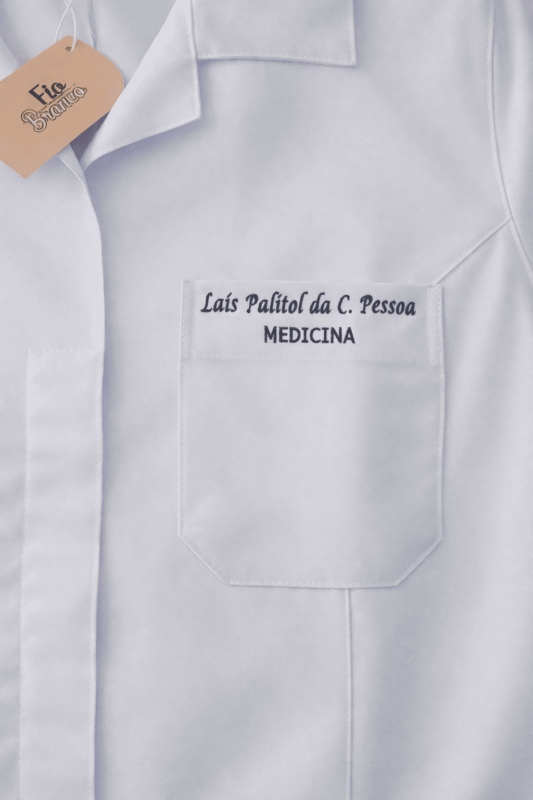 Bordado com nome e curso no bolso de um jaleco branco